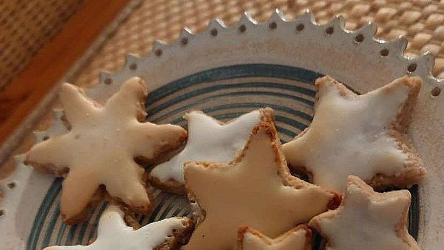 selbstgebackene Zimtsterne liegen neben- und übereinander auf einer blau-weißen Steinzeug-Étagére