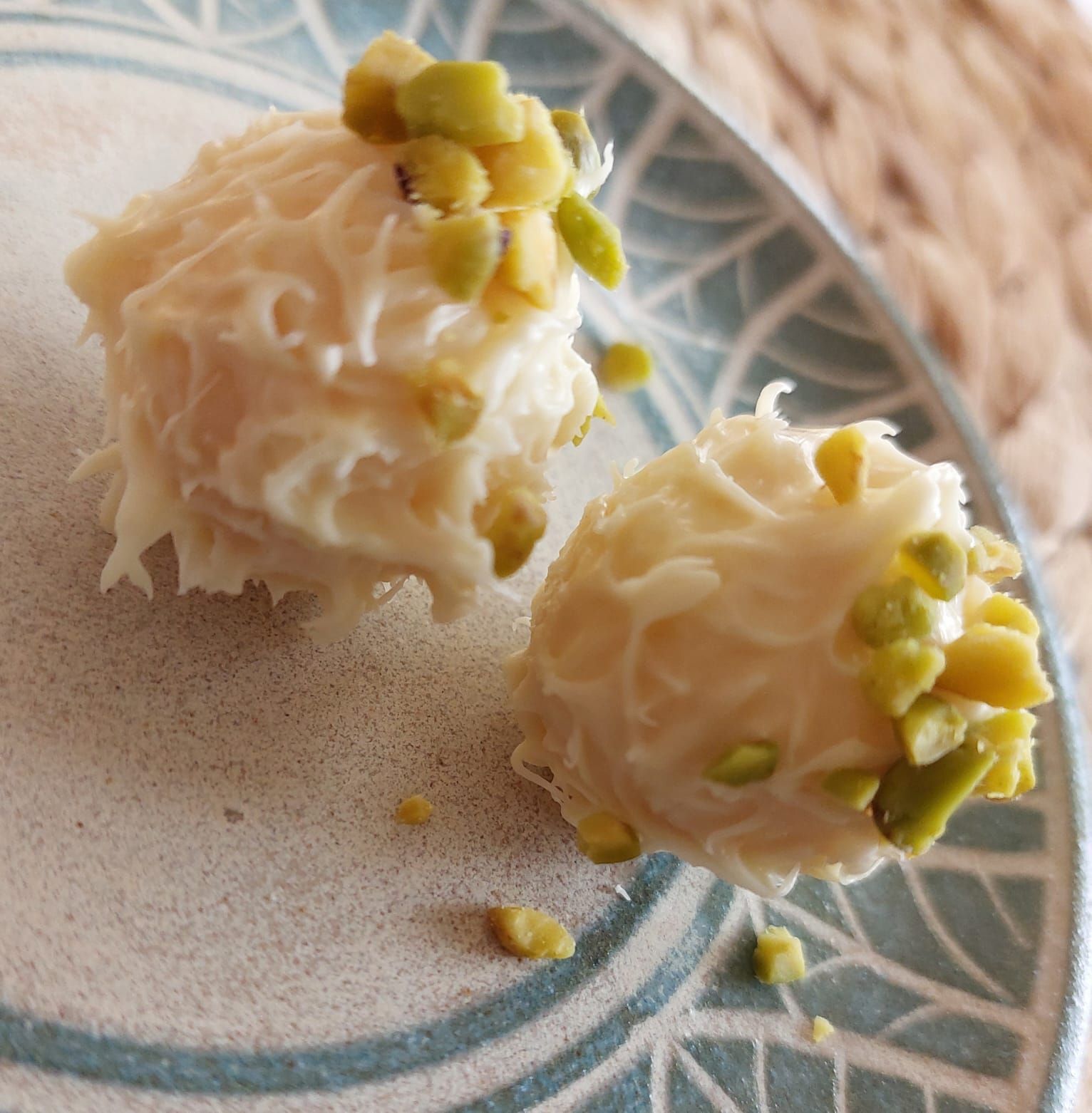blaue Schale und blauer Teller mit Blumendekoration gehalten von Händen