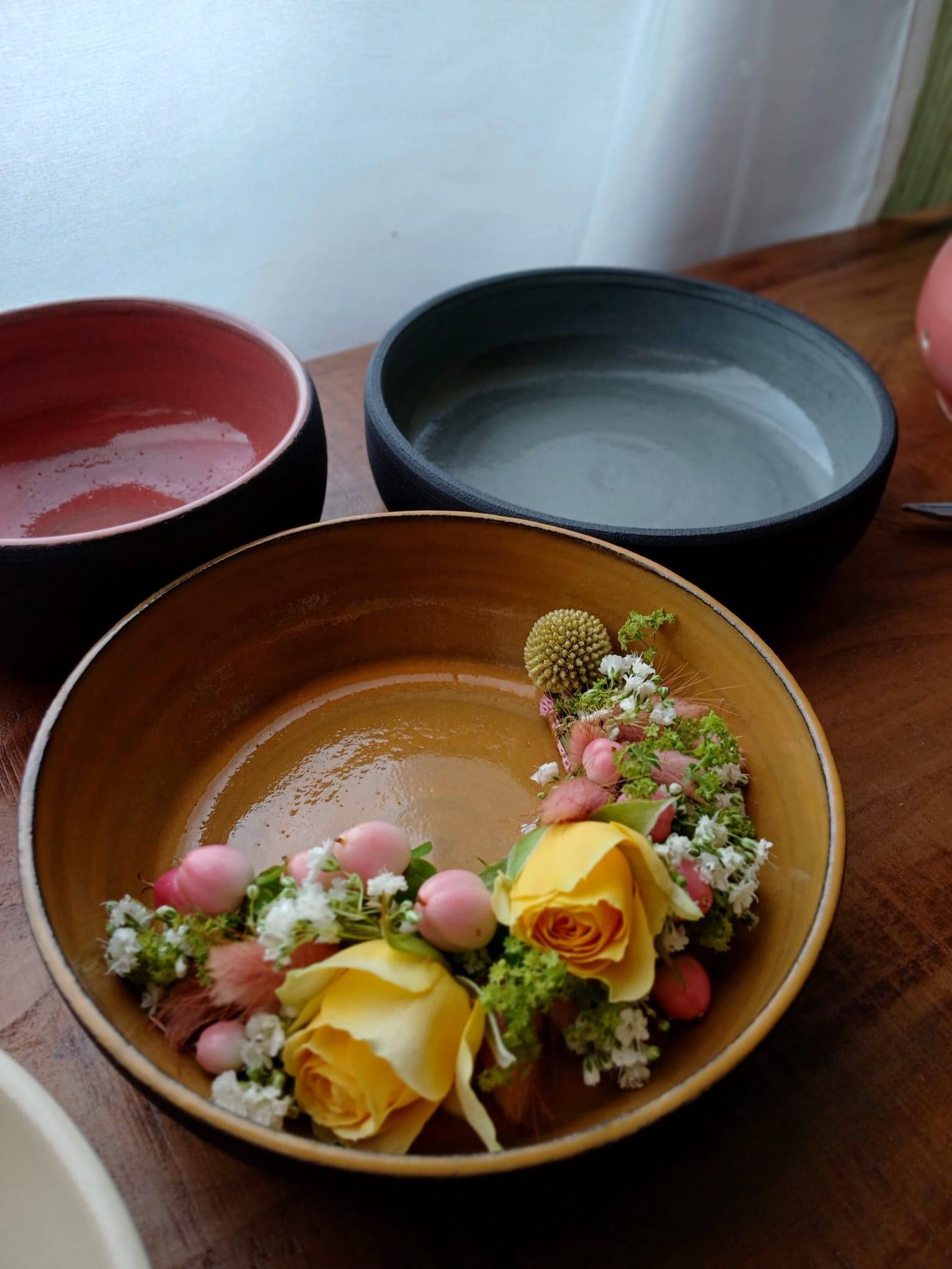 dreifarbige Schüsseln (Erdbraun, Rot und Graublaue) mit Blumenkranz - Farbpsychologie von Keramik