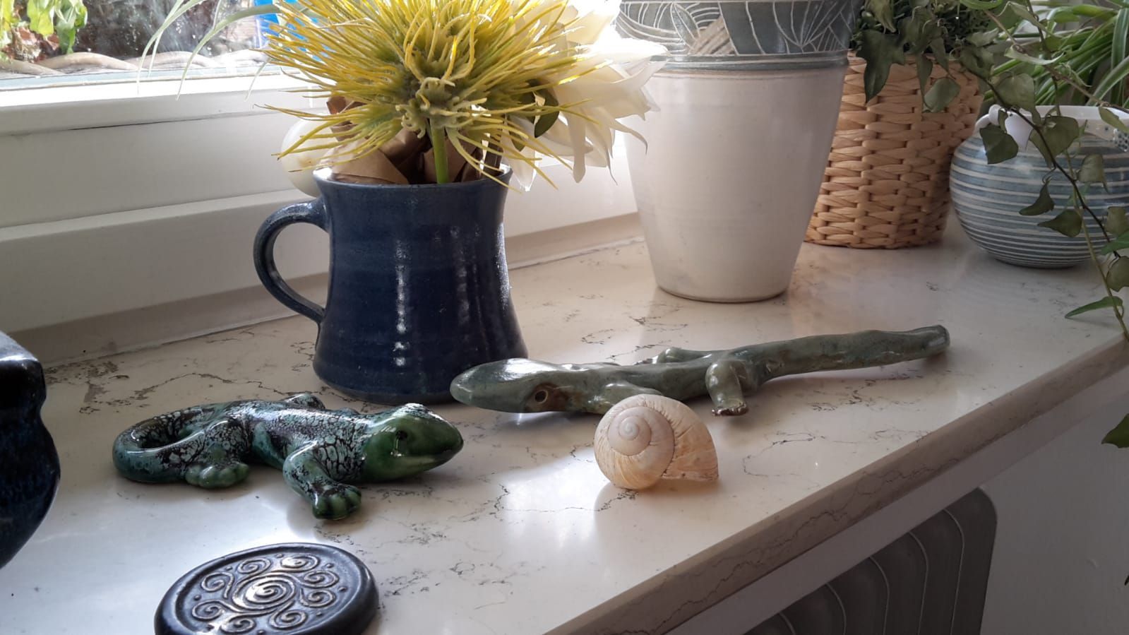 Freunde des Krüglmarkts - Fensterbank mit verschiedenen Keramiken: Vase, Tasse, Eidechse und Rundschild Freunde des Krüglmarkts - Fensterbank mit verschiedenen Keramiken: Vase, Tasse, Eidechse und Rundschild