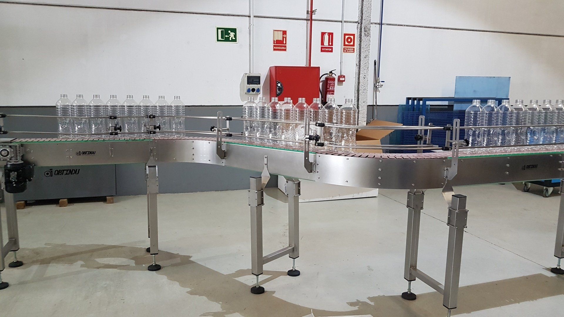 Stainless steel and plastic hinge transport system. OBTINDU, designed to transport containers, bottles, cans, boxes, etc. with straight sections and curves of the angle that the client needs up to 180º. Robust conveyors with height-adjustable feet,