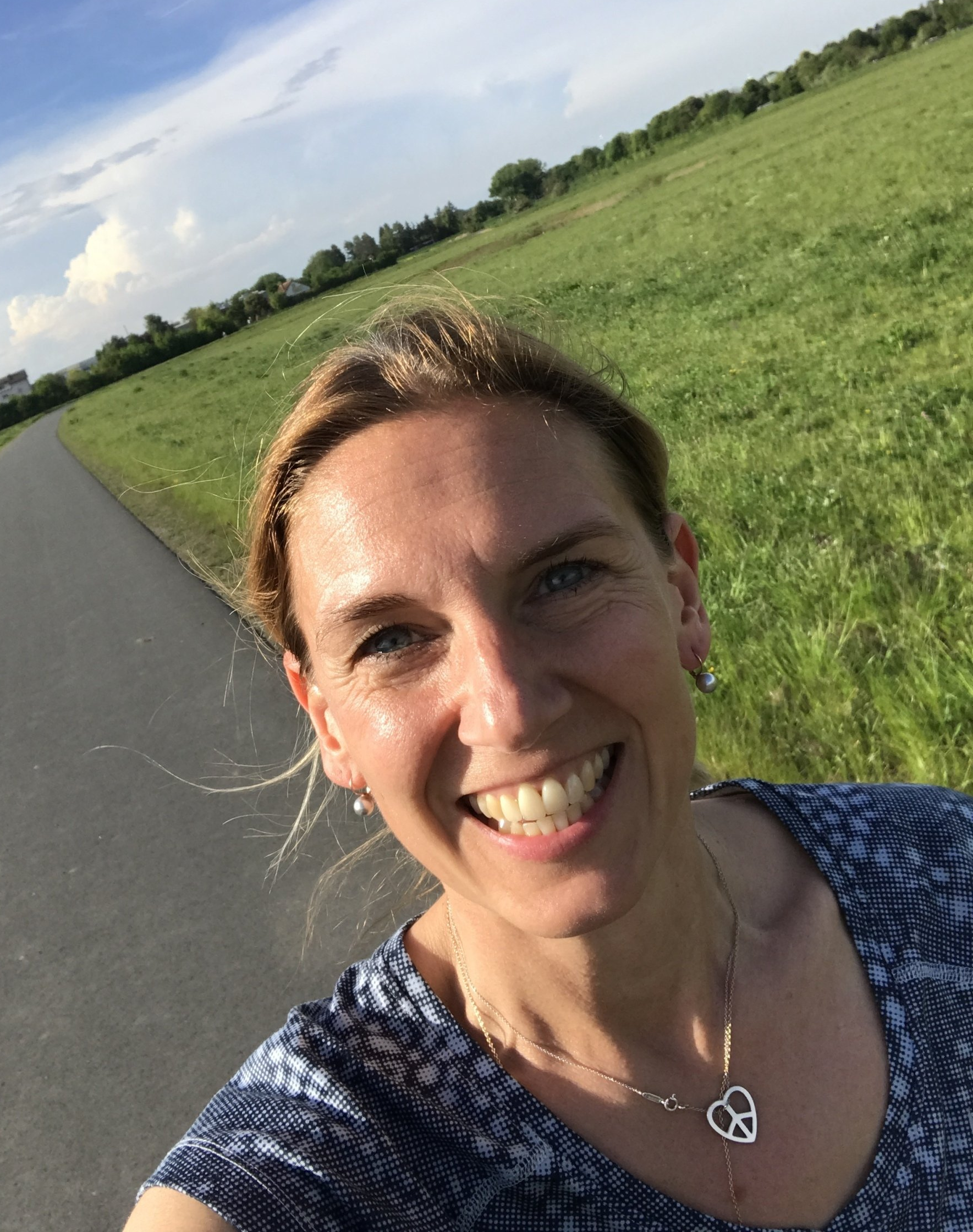 Sylvia Kurth-Frede joggt im Feld und lacht in die Kamera