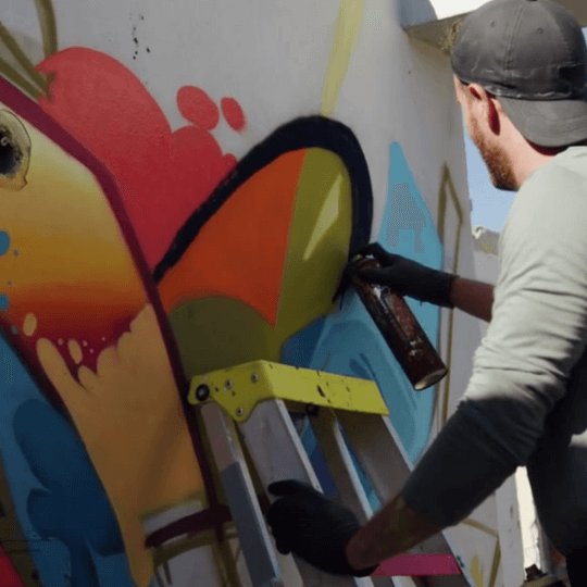 A shelf with colorful aerosol spray cans at Hemco Paint store.