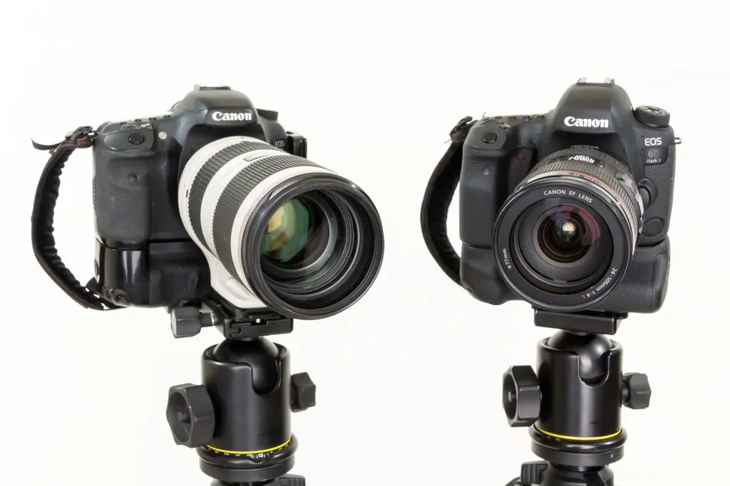 Two professional cameras on stands with a white background