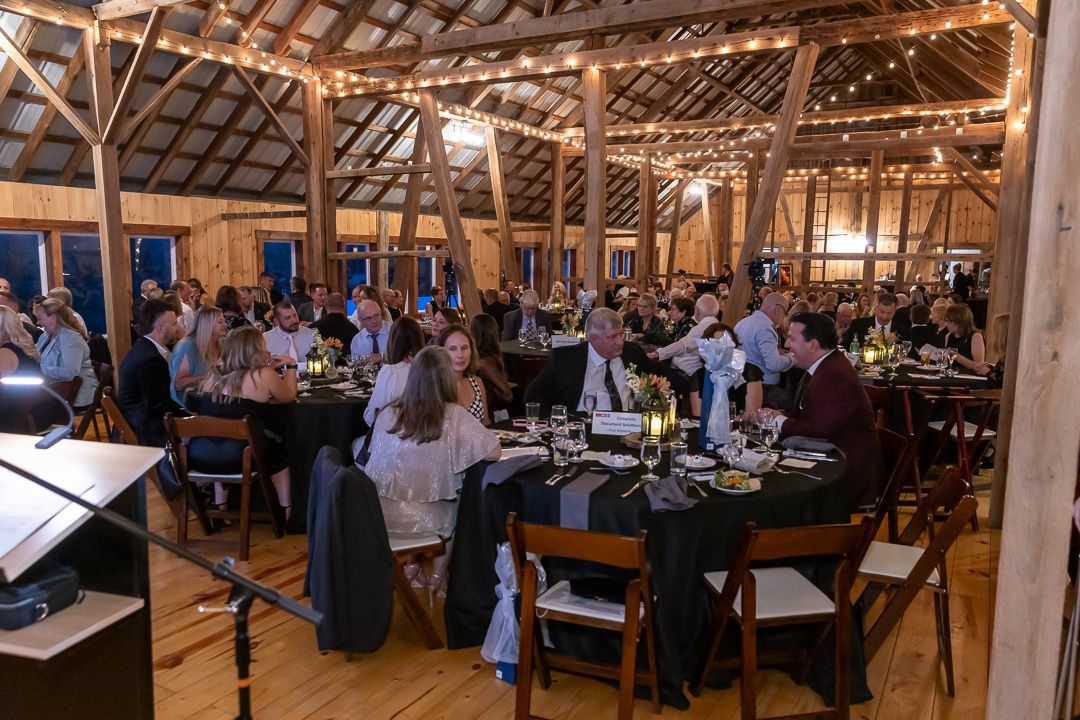 A photographer dressed in black preparing to take a group photo of award recipients.