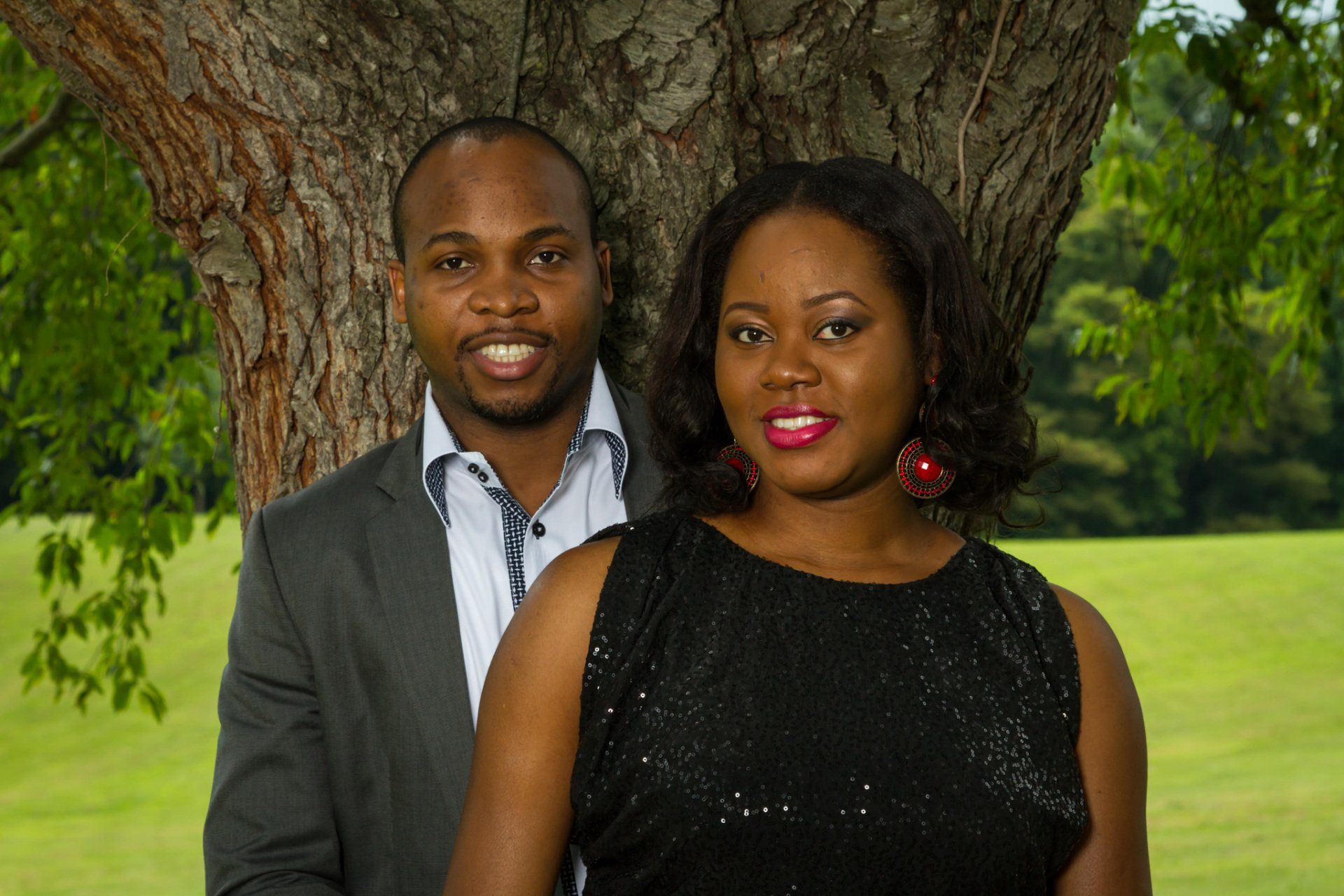 A couple standing under a large oak tree for a couples portrait.