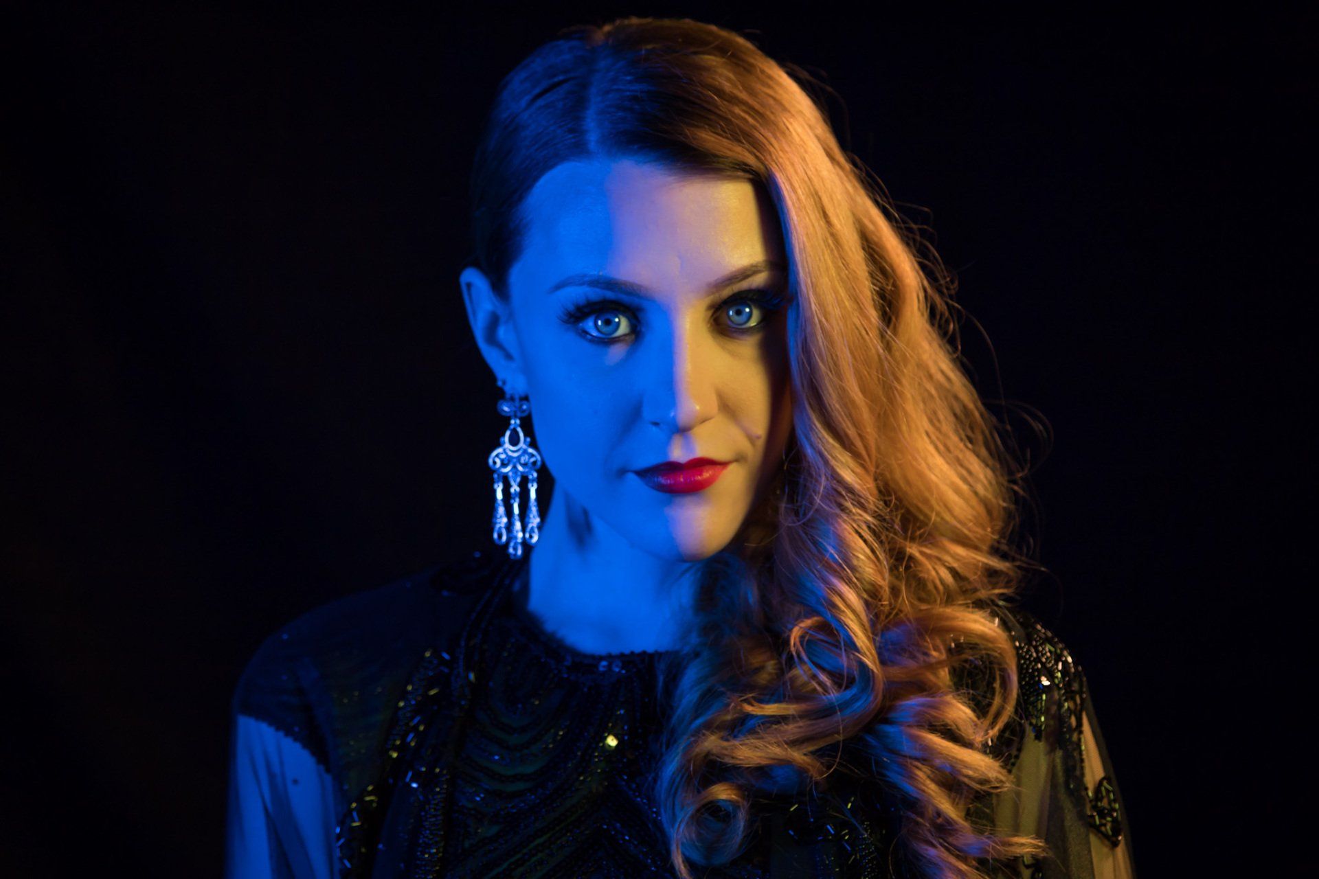 A creative colored amber and blue portrait of a woman in against a black background