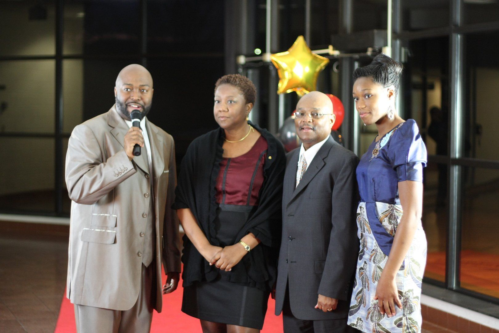 Three people being interviewed by another person with a microphone on the red carpet.