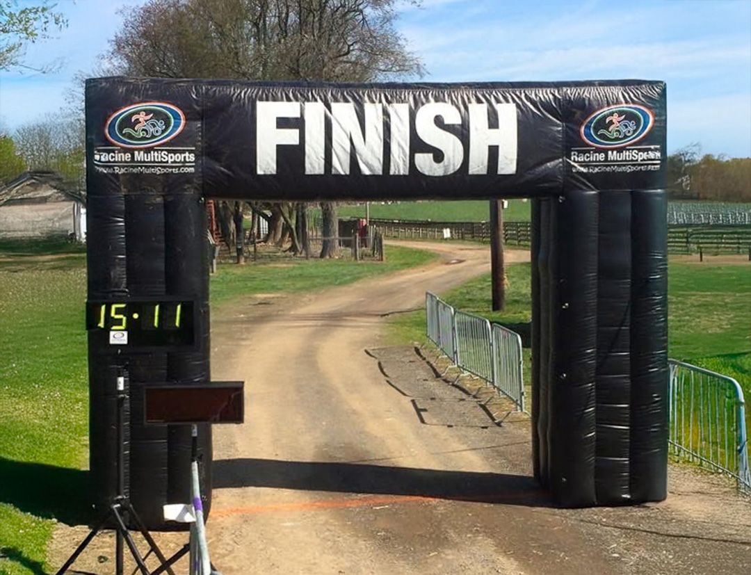 The finish line of a race on a dirt road with no runners visible.