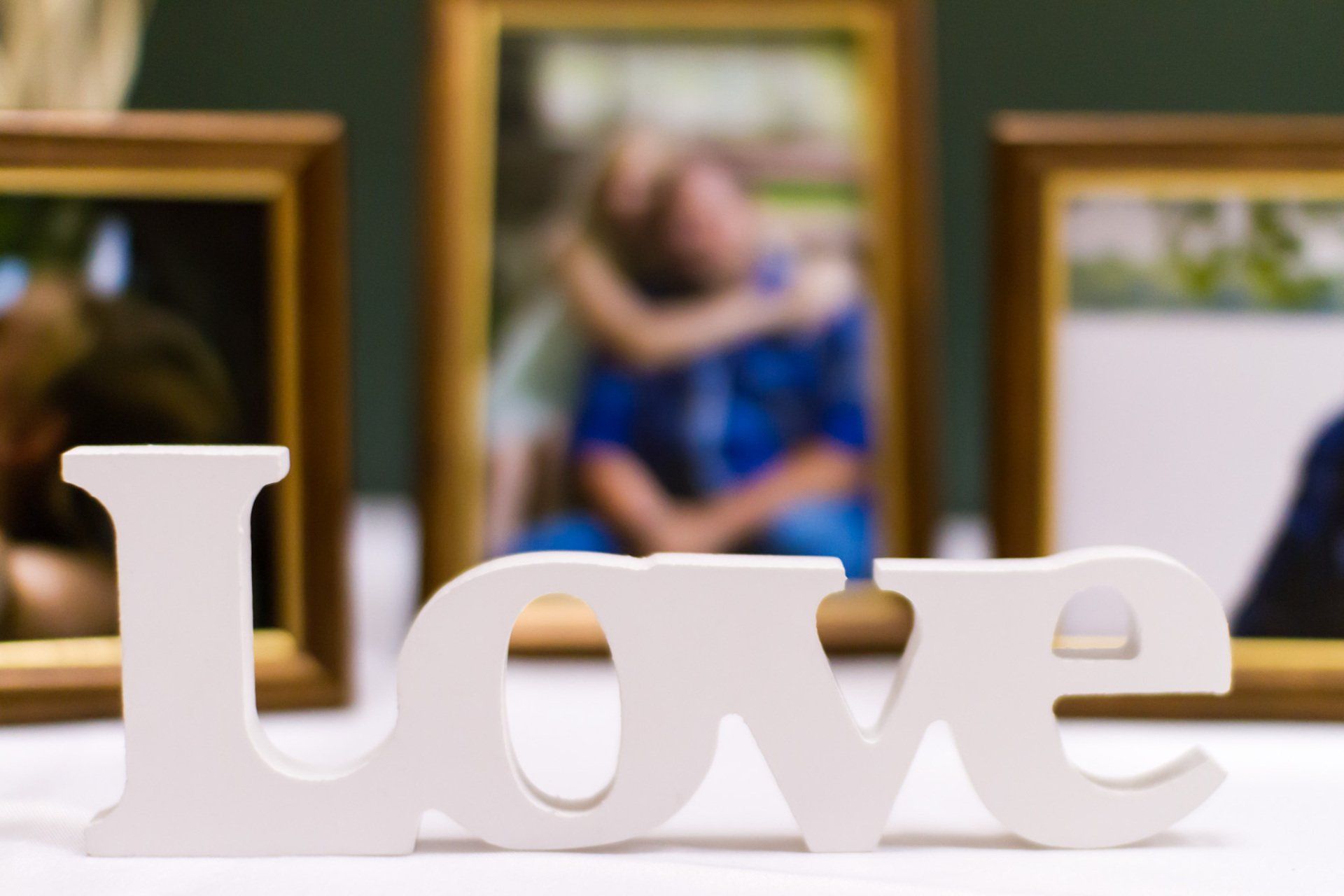 A photo of white letters spelling love with photographs in the background