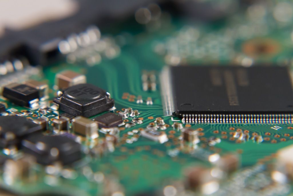 A close up picture of a computer component board with computer chips and circuits.