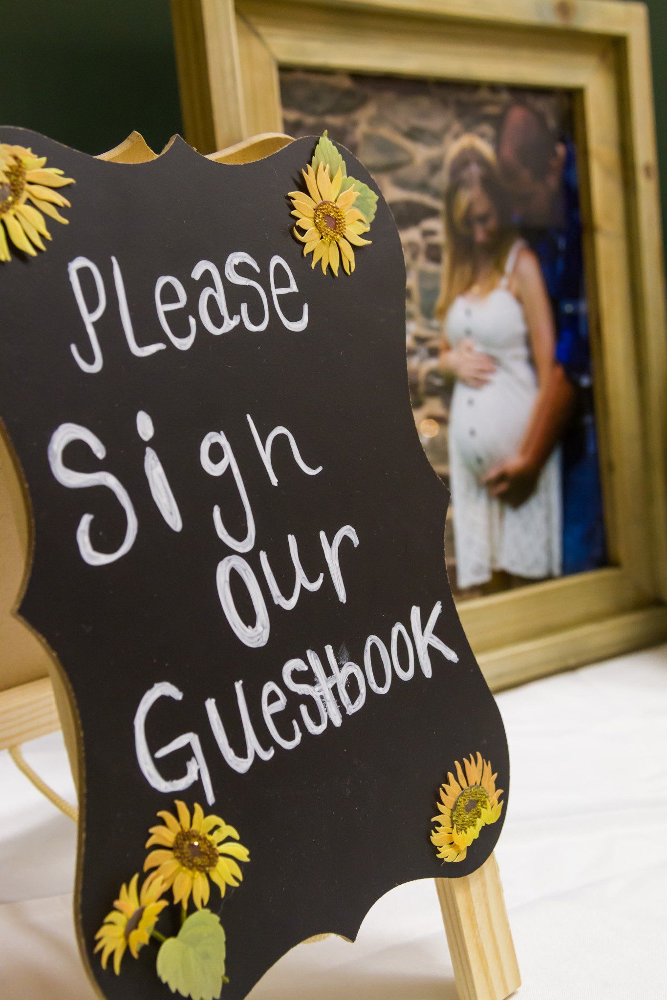 A photo of the guestbook sign with photographs in the background