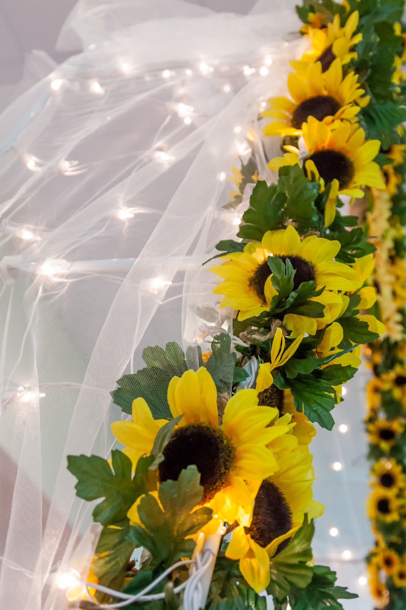 A picture of white tulle and yellow flowers from the reception