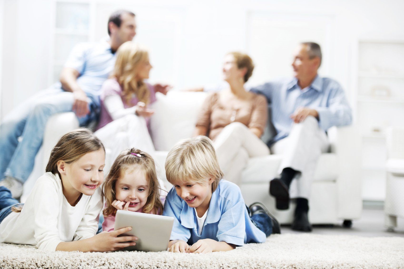 Parents, grands-parents, beaux-parents et enfants tous ensemble détendus et souriants dans le séjour