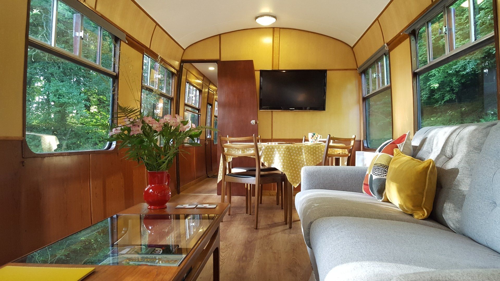 The saloon lounge-diner is comfortably furnished with  1960s vintage furniture, enjoys panoramic views over the green platform. For the evenings, the blinds provide privacy while choosing to lounge in front of the television.