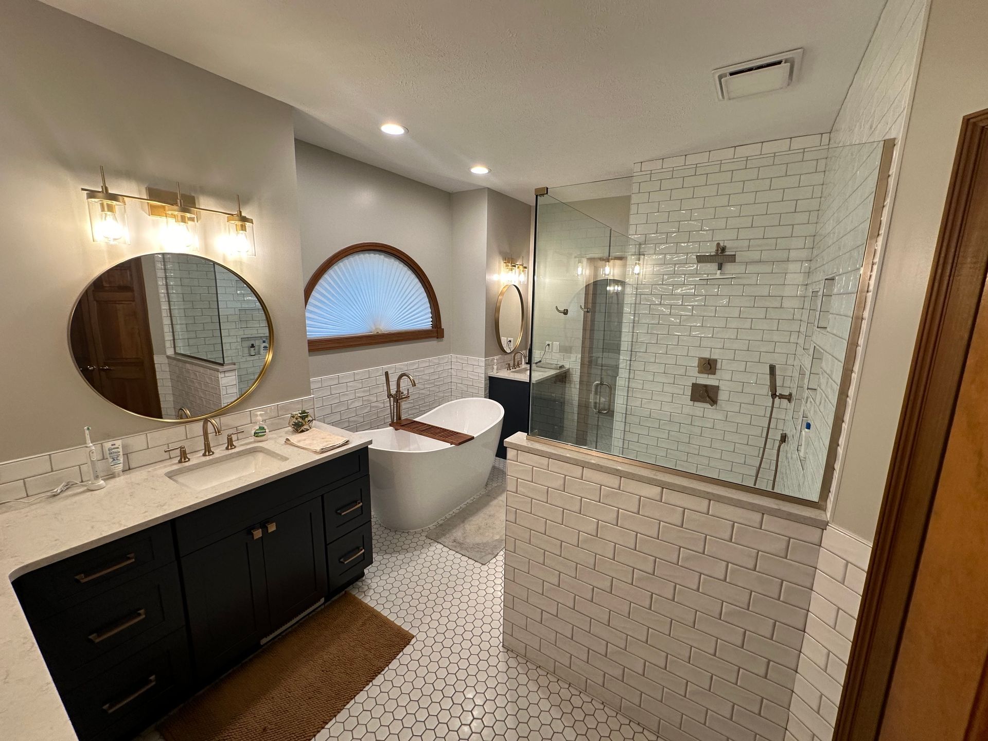 Modern bathroom remodel featuring a large walk-in shower, dual vanity, and luxury finishes by Kitche