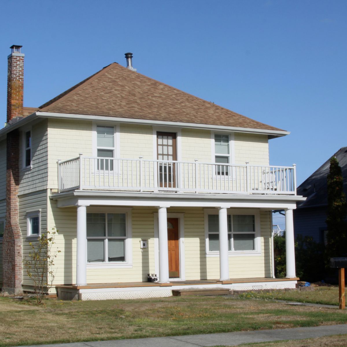 Transform classic homes for modern living Colonial style home with porch and balcony representing renovation and modernization opportunities