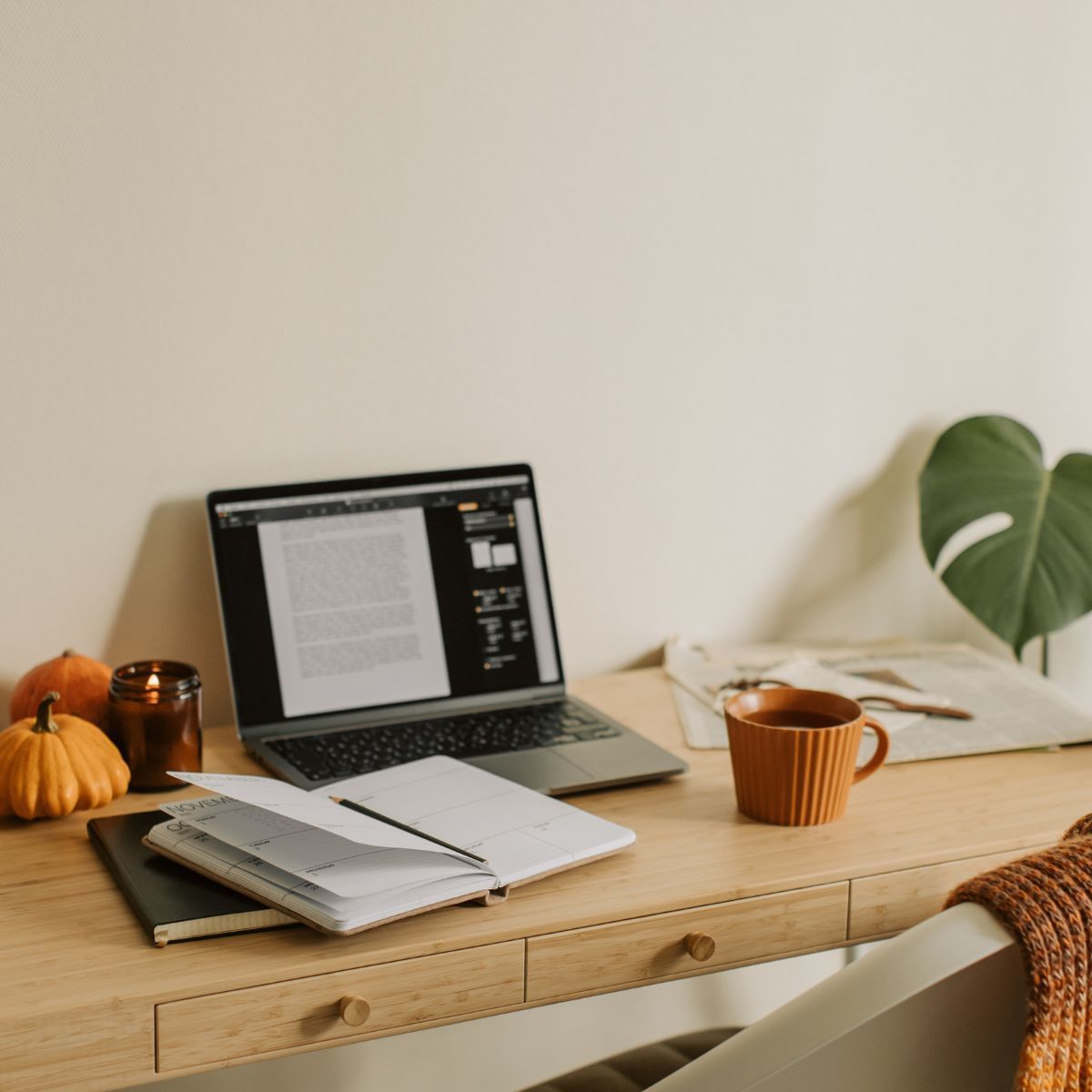 Make your workspace warm and inviting Cozy home office desk with planner, laptop, and warm decor accents