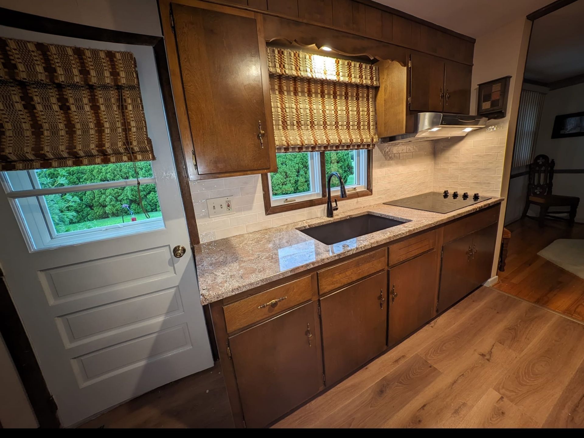Renovated kitchen sink with modern backsplash and faucet