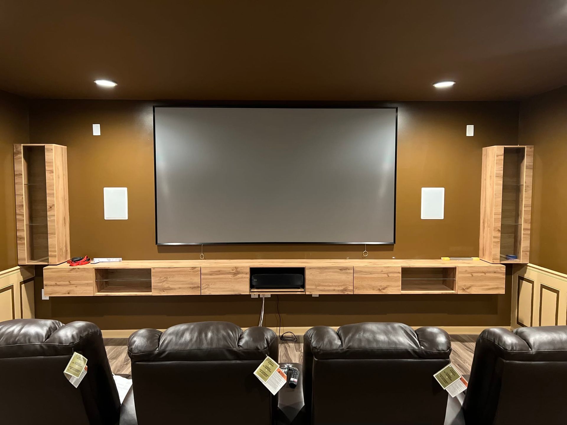 Custom-built home theater and entertainment center with leather seating and wall-mounted screen in