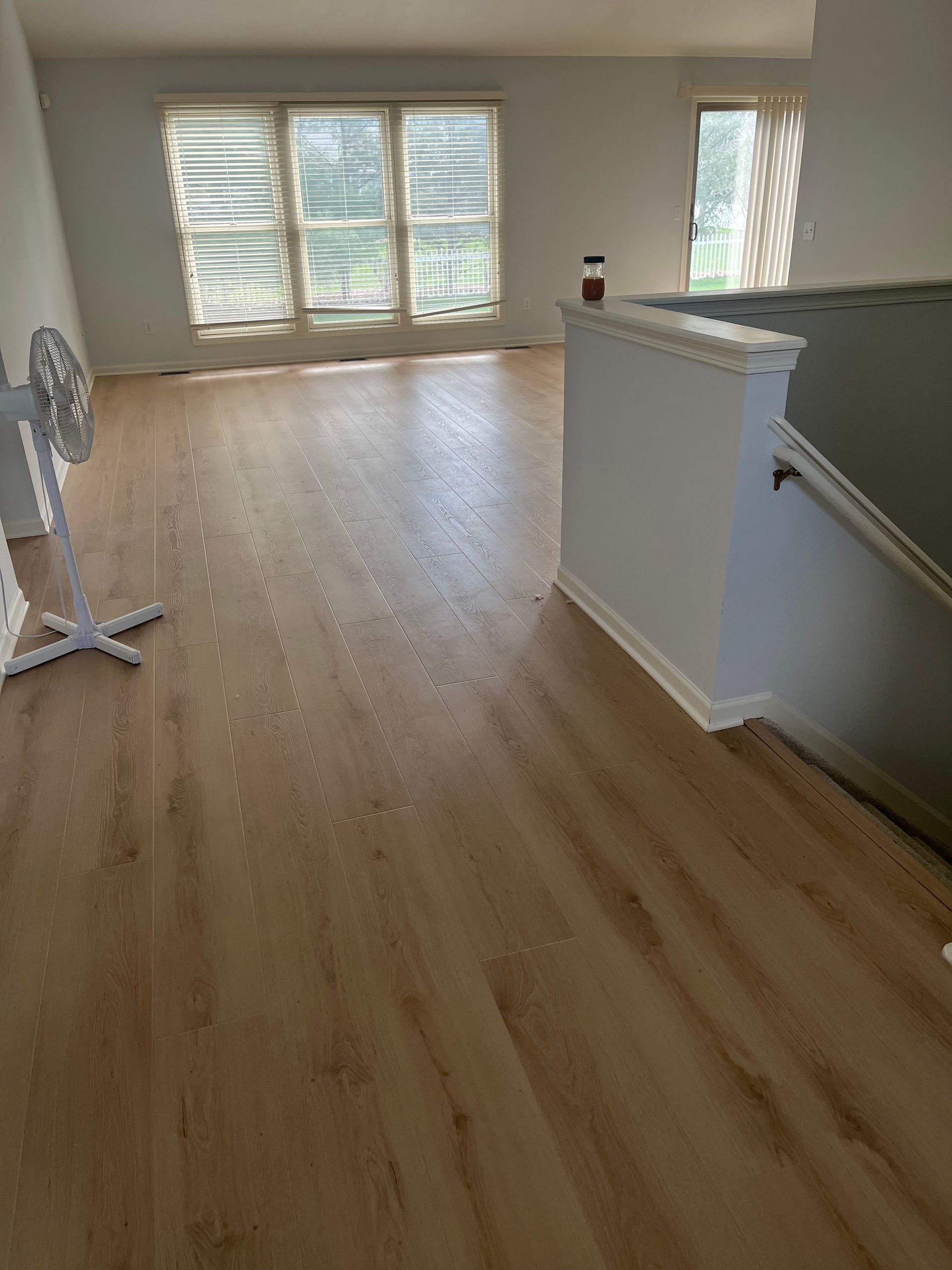 Bright and airy living room with wide plank wood flooring Modern Lehigh Valley living room renovation with wide plank wood flooring and natural light