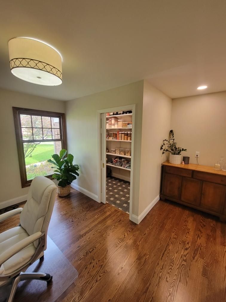 Beautiful remodeled home office with hardwood floors, large window, and organized walk-in pantry in