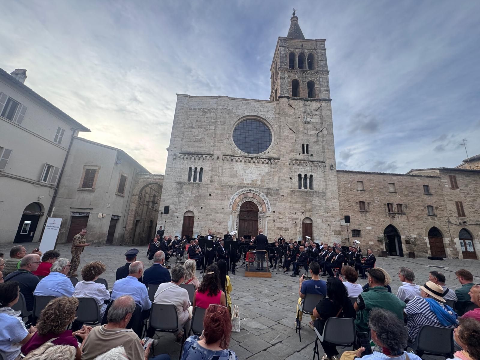 Concerto in una piazza di Bevagna, con una chiesa sullo sfondo.
