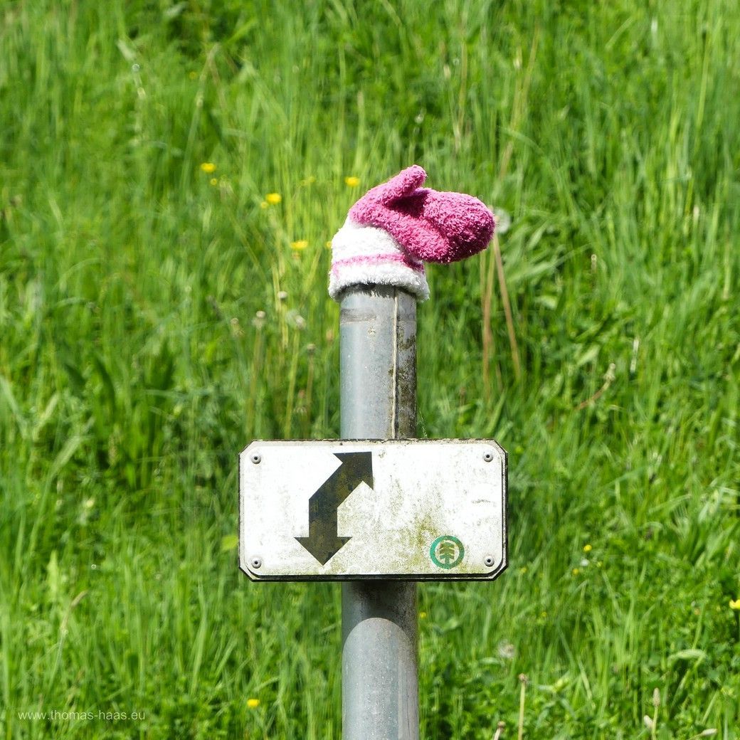 Kinderhandschuh verloren und gefunden... Ein einsamer Kinderhandschuh als Überbleibsel aus dem Winter, an einer Wegemarkierung befestigt...