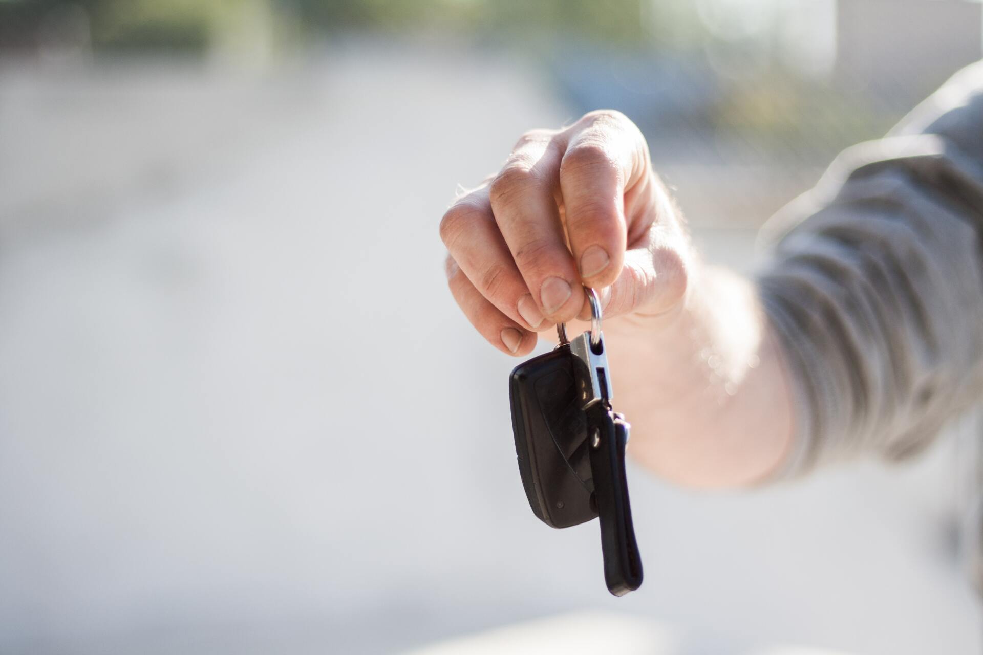 a mans arm and hand holding van keys