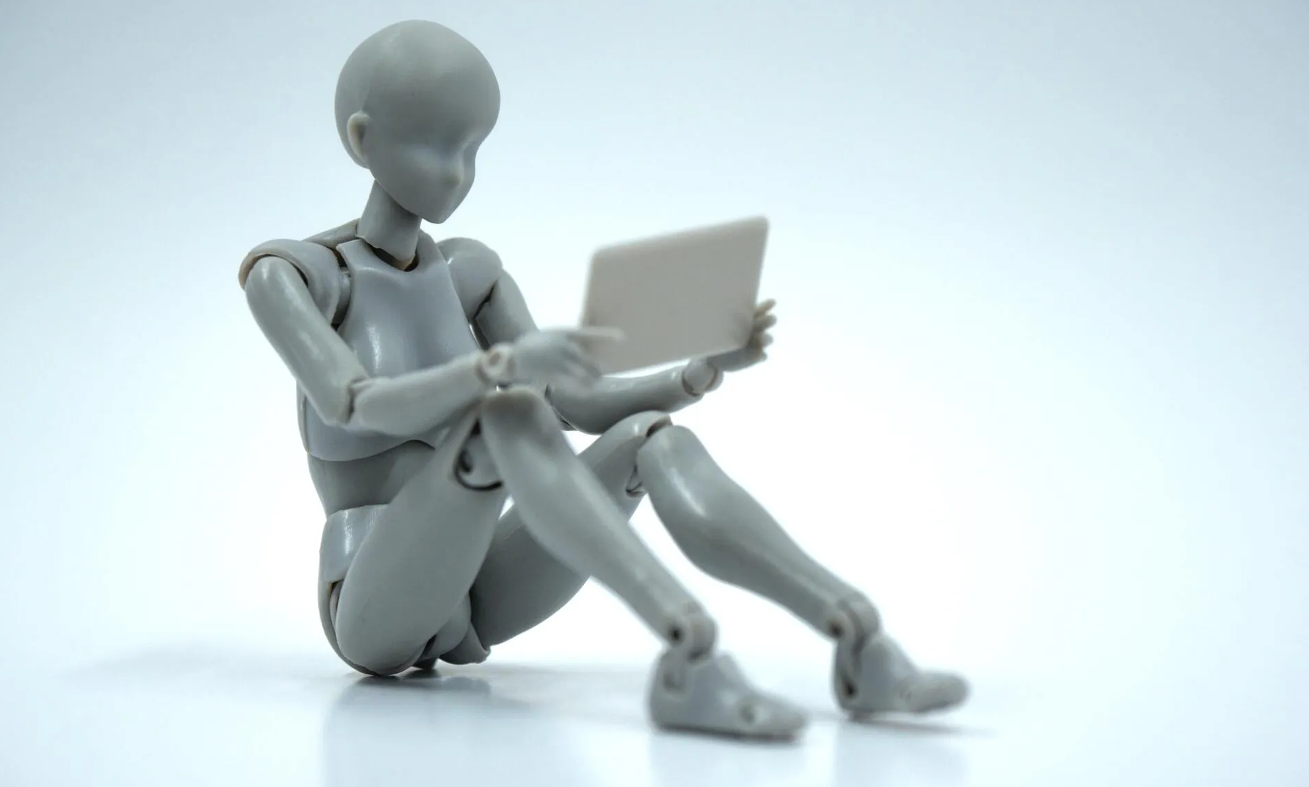 Daten, Fakten, Texte suchen und finden die Menschen heute vor allem im Internet Gliederpuppe sitzt auf dem Boden und schaut auf Tablet-Computer sitzt a