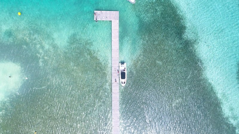 Vue aérienne du bateau Hippocampe à quai sur l’îlet Madame, au cœur des lagons turquoise du François en Martinique.