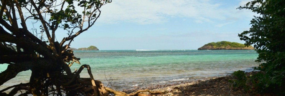 Depuis la plage de l’îlet Madame, panorama sur une mer éclatante aux dégradés de bleu et de turquoise.