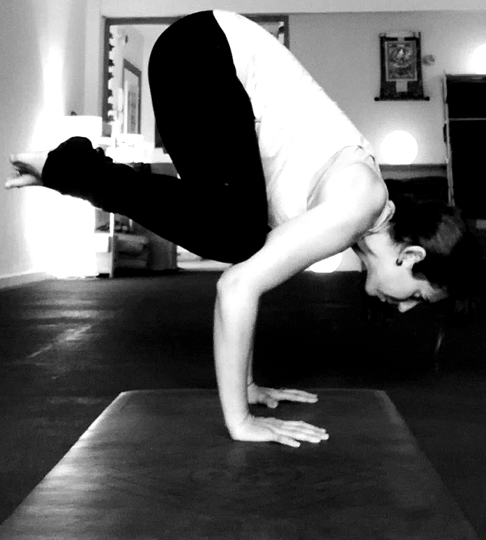 Eva en postura de Kakasana en clase de yoga en Alpedrete.