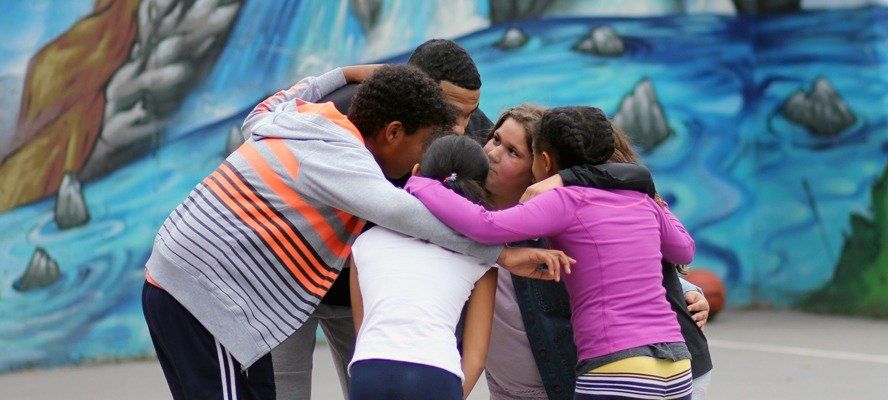 Children huddle together to discuss their game strategy.