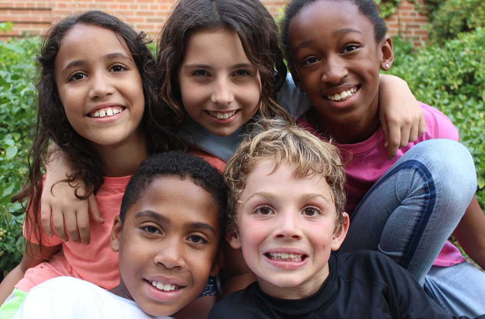 A group of five children smiling at the camera.