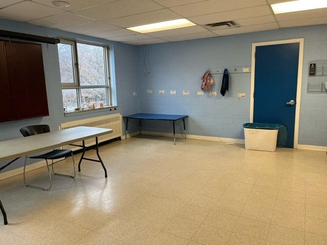 The far end of the party room showing the windows, furniture and coat hooks.