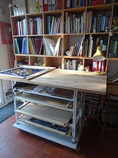 Présentation de l'atelier Art'elkin, la table de découpe et de montage des vitraux avec ses étagères pour les projets en cours