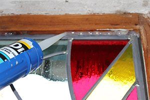 Art'lekin, vitrail sur-mesure, Jeannala & Seppala, étape de création, mise en place de silicone en périphérie du vitrail.