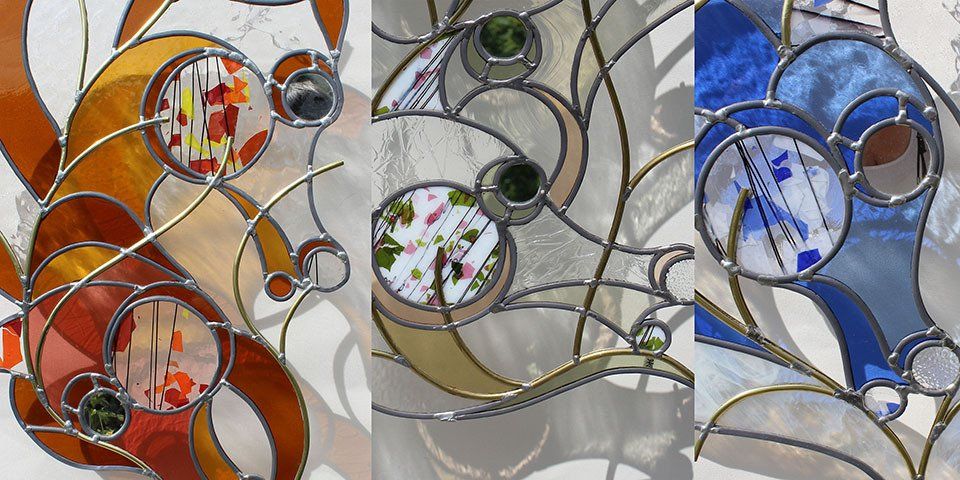 Tableaux-vitraux réalisés par Art'lekin en technique traditionnelle, contour échancré et évidements entre pièces de verre, trois vitaux représentant des chevaux-hippocampes tout en courbures élégantes, couleurs principales : ambre pour l'un, neutre pour un autre, bleu pour le troisième, dimensions environ 50 x 60 cm