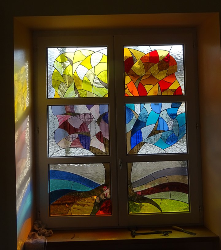 Art'lekin, vitraux sur-mesure, Jeannala &Seppala, vitraux personnalisé représentant les personnages Jeannala et Seppala dans un décor alsacien