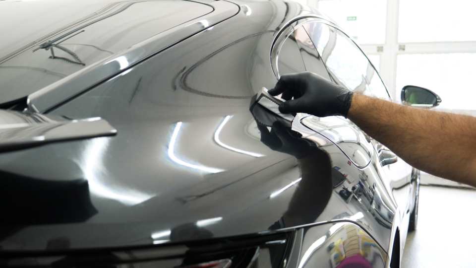 a person polishing the side of a car