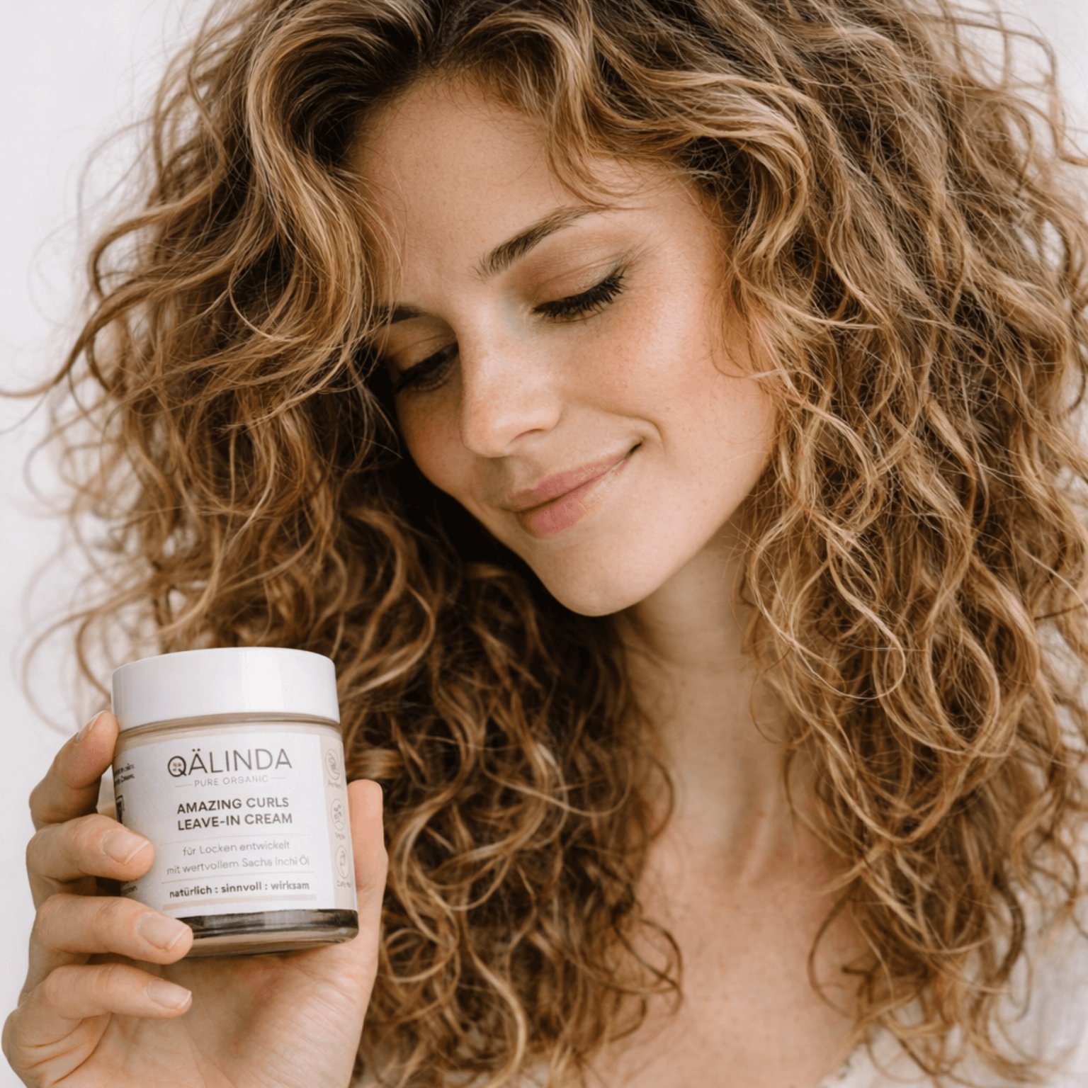 Die Amazing Curls Leave-In Cream mit Sacha Inchi Öl im Glastiegel auf einer Marmorfliese.