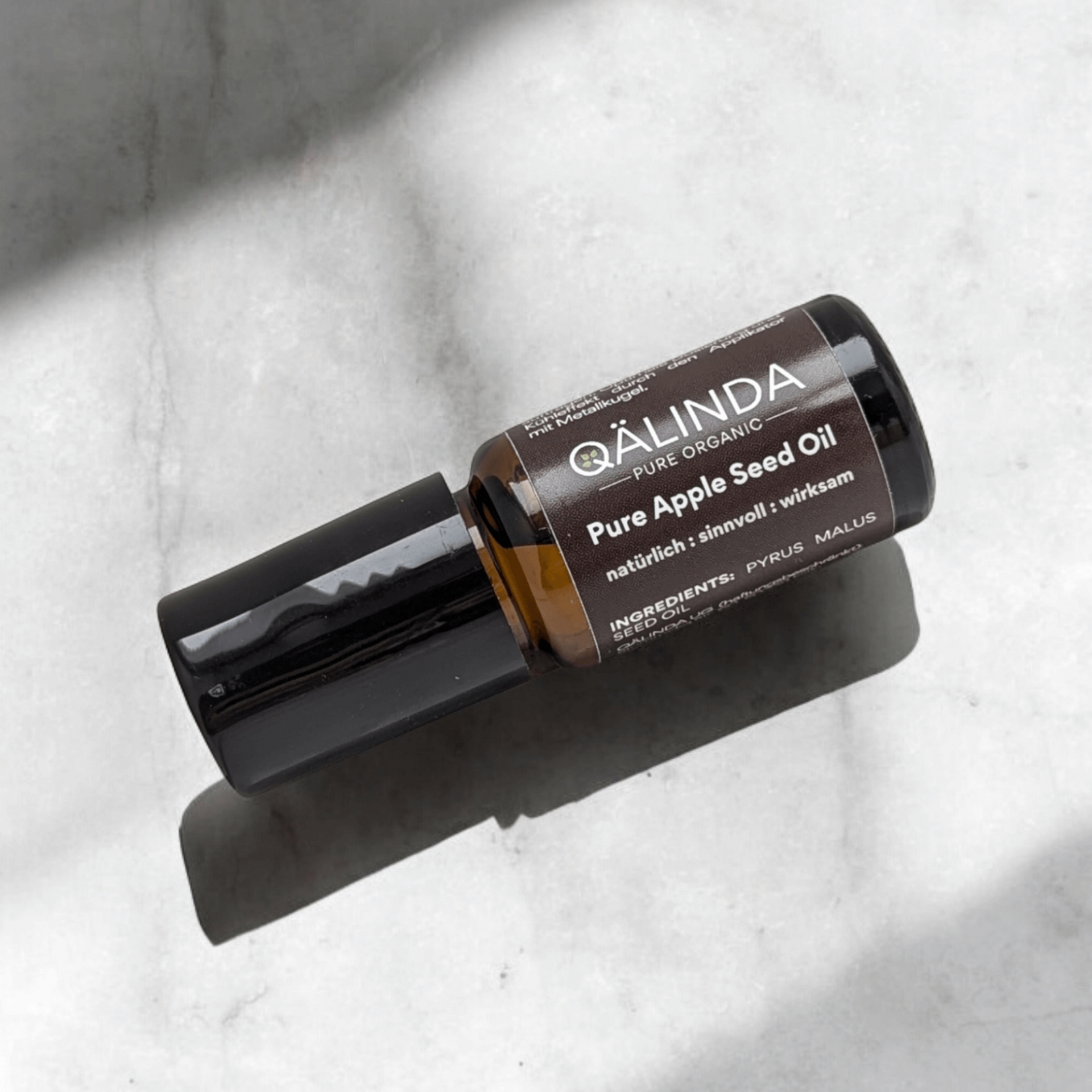 Pure Apple Seed Oil Flasche liegend auf Marmor