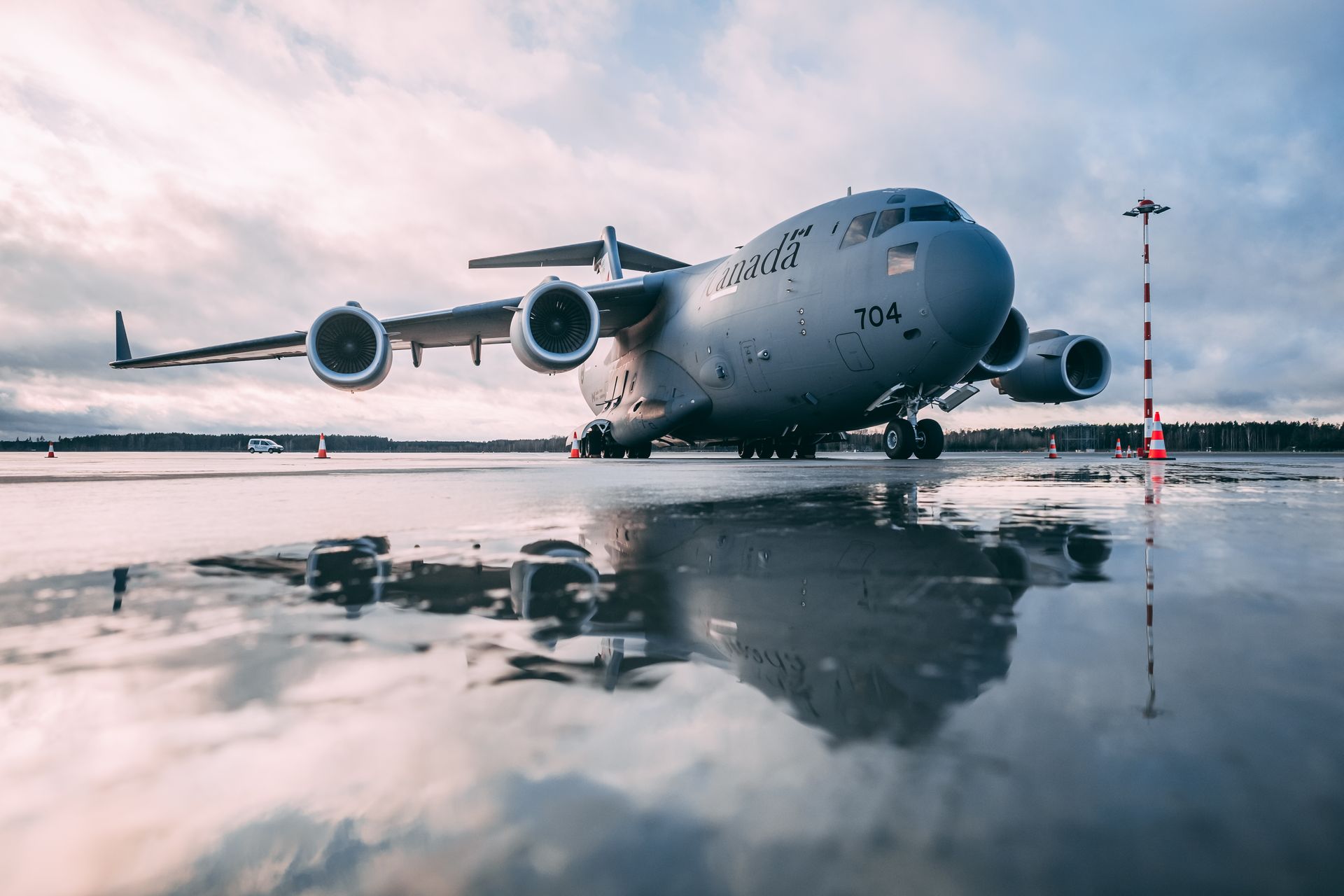 Royal Canadian Air Force C-17 Globemaster III parked on a wet runway under cloudy skies