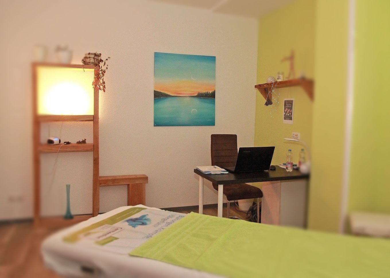 Behandlungsraum für Ergotherapie Patienten. Liege mit Schreibtisch und Stuhl.