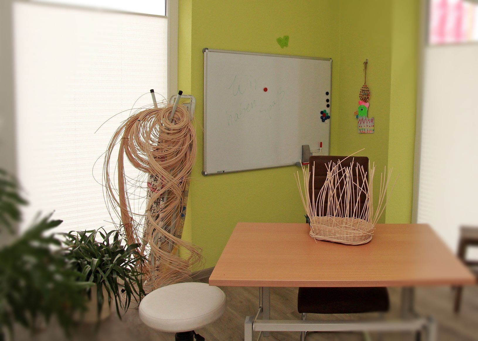 Behandlungsraum für Ergotherapie mit Tisch und Stuhl.