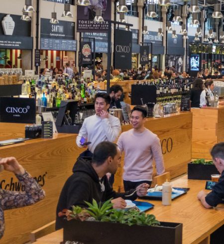 men walking through restaurant food hall