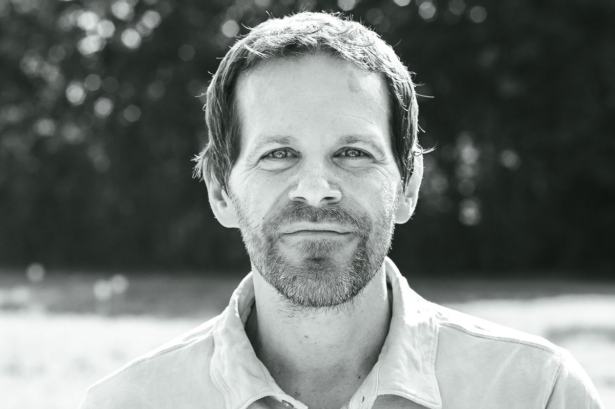 Ein Bild des Psychotherapeuten Florian Friedrich auf einem Feld. Ein Bild des Psychotherapeuten Florian Friedrich. Die Farben sind schwarz-weiß.