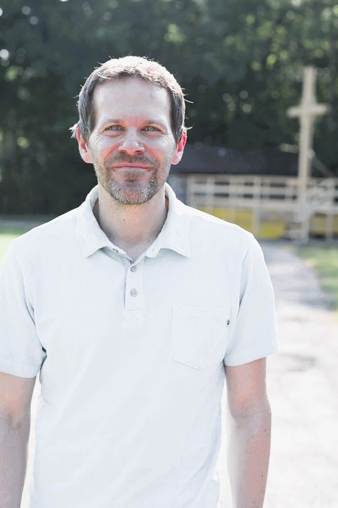 Ein Bild des Psychotherapeuten Florian Friedrich. Im Hintergrund ist ein Kreuz zu sehen. Die Farben sind weiß, strahlend.