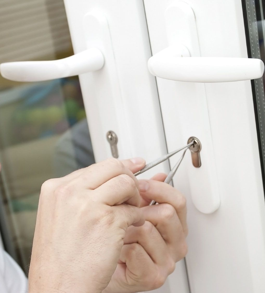 2 Hände mit einem Pick am Schließzylinder